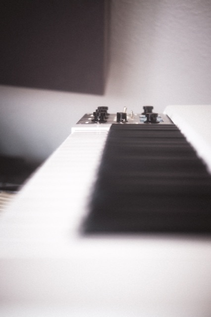 Nahaufnahme einer Keyboard-Tastatur mit den Reglern eines Effektgeräts, sehr geringe Schärfentiefe.